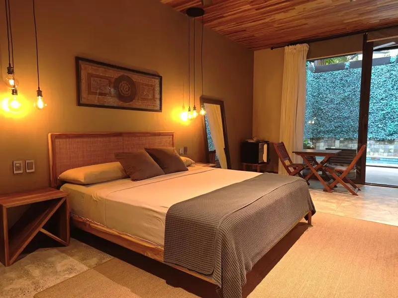 Une chambre lumineuse avec un grand lit et un accès à une terrasse.