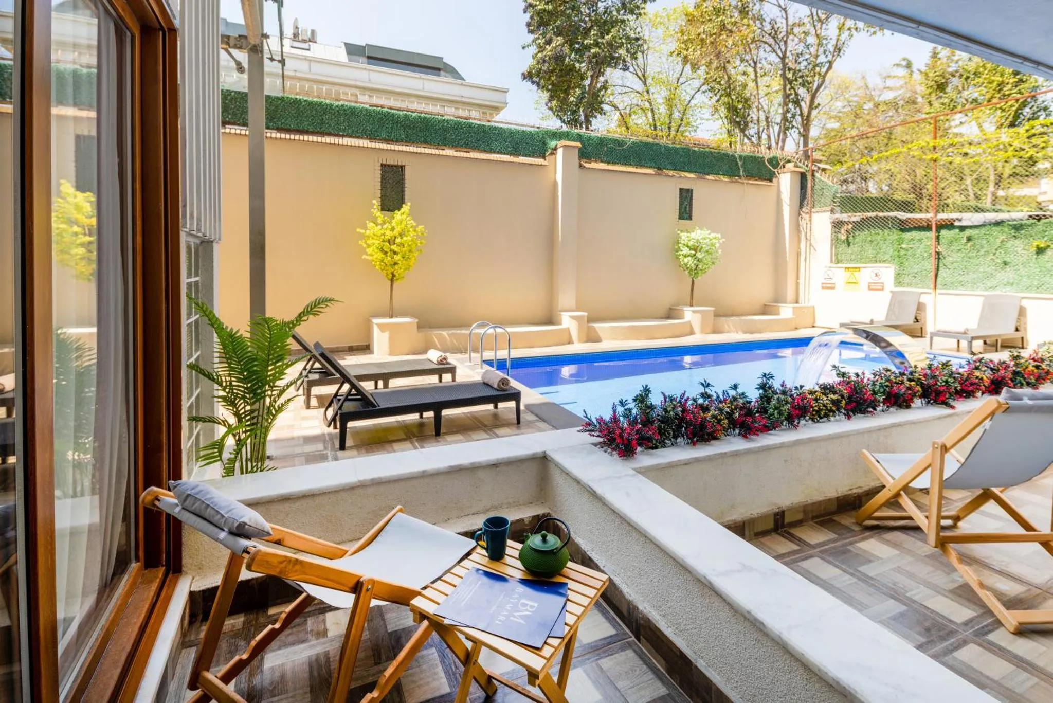 Terrasse avec transats et petite piscine entourée de végétation.