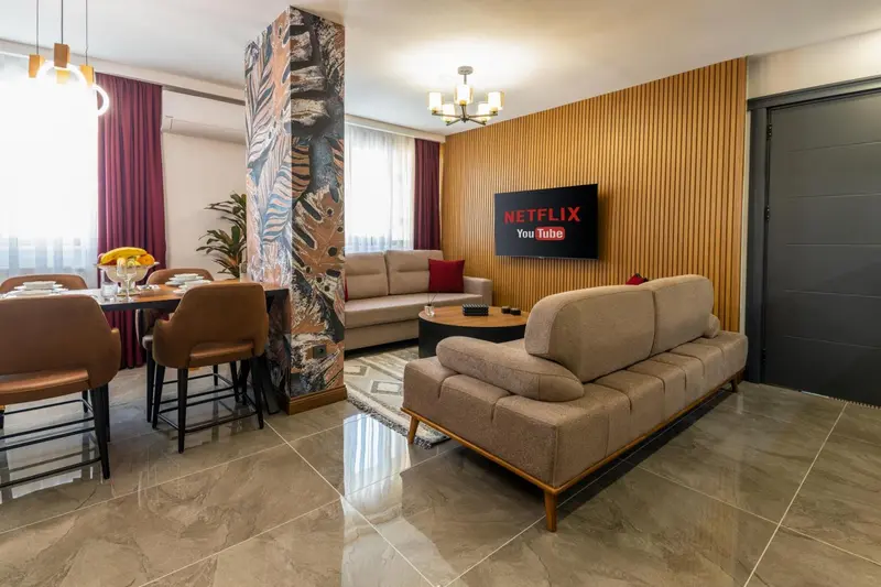 Un espace de vie intérieur combine un coin repas et un salon avec canapés et télévision.