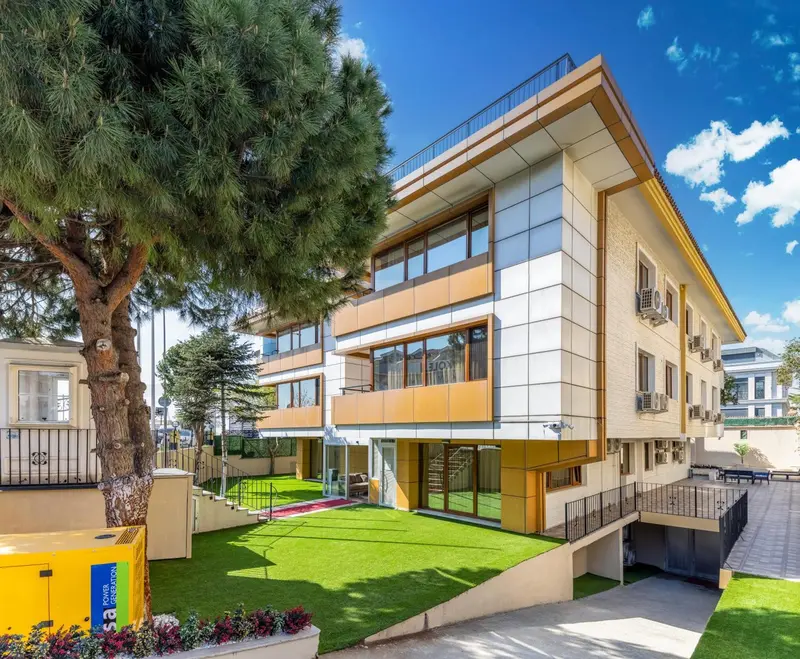 Bâtiment moderne à l'architecture épurée avec un jardin verdoyant.