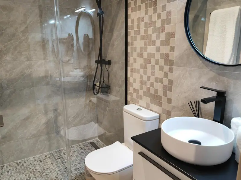 Une salle de bain moderne avec douche à l'italienne et lavabo sur meuble.