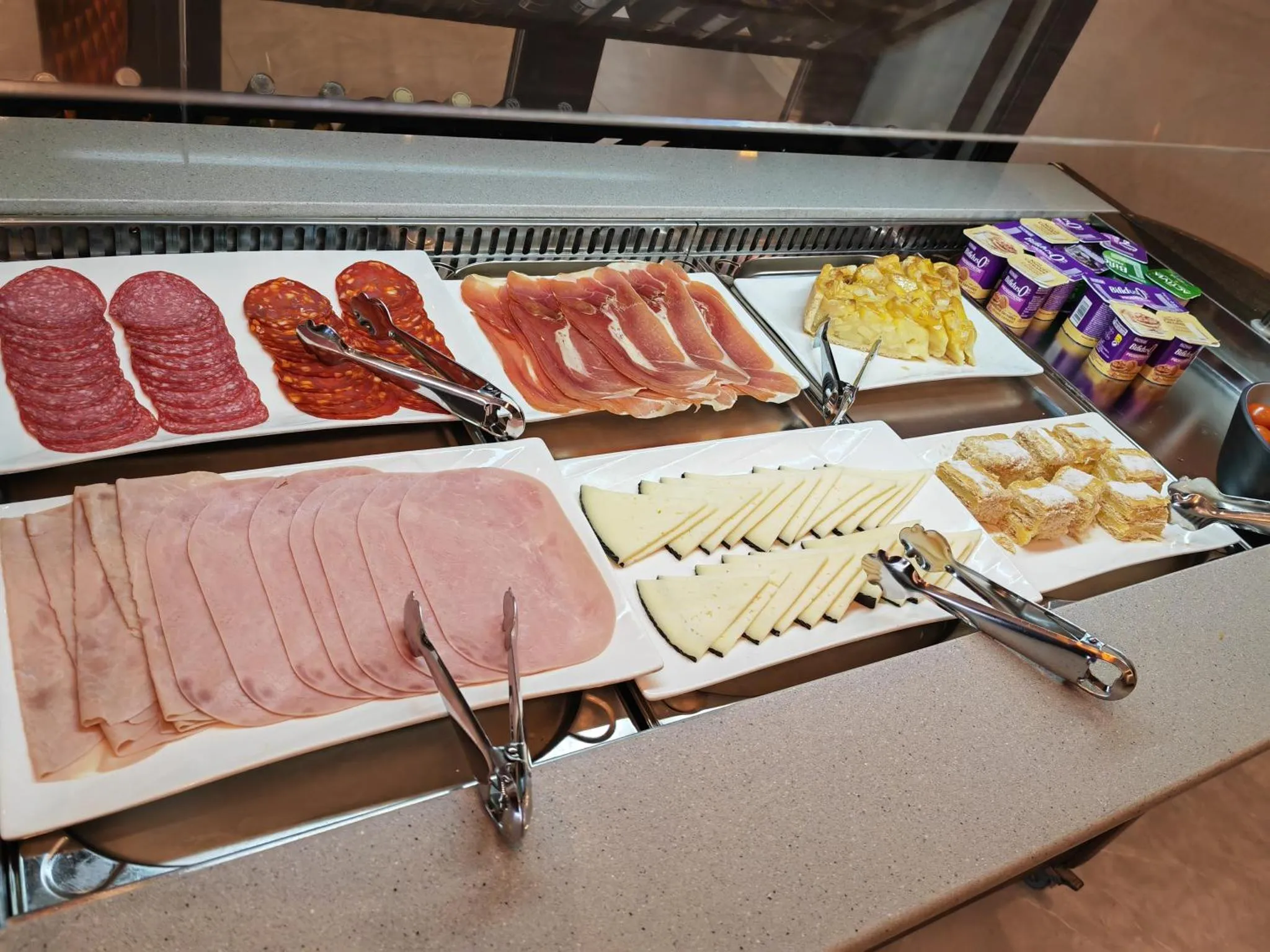 Présentation de charcuteries et de fromages variés sur un buffet.
