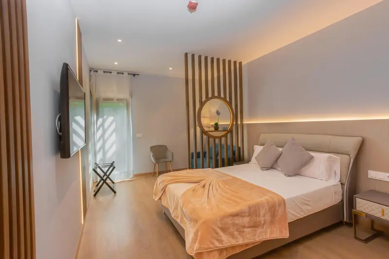 Une chambre moderne avec un grand lit et une télévision murale.
