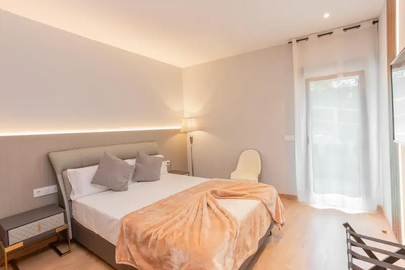 Une chambre lumineuse avec un grand lit et un accès à une terrasse.