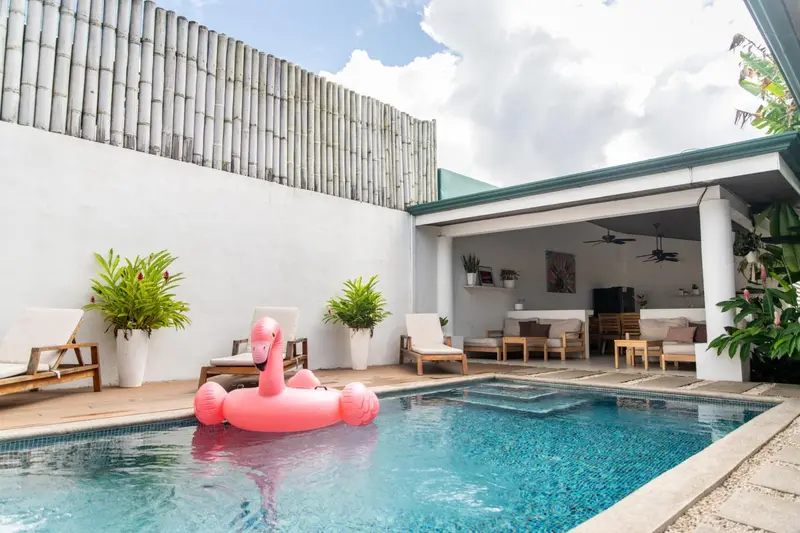 Espace piscine avec mobilier de détente et décoration florale.