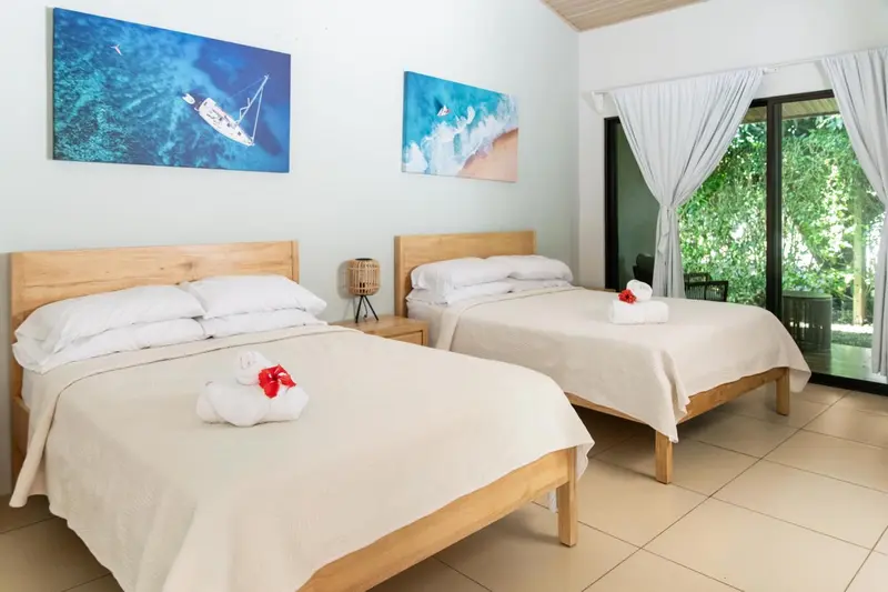 Une chambre lumineuse avec deux lits simples décorés de fleurs.