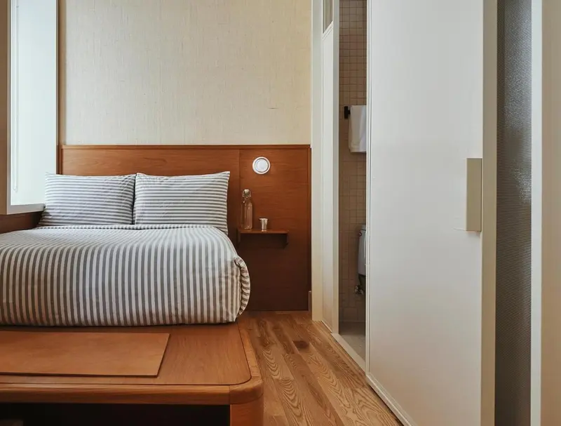 Une chambre lumineuse avec un lit double et un mur en bois.