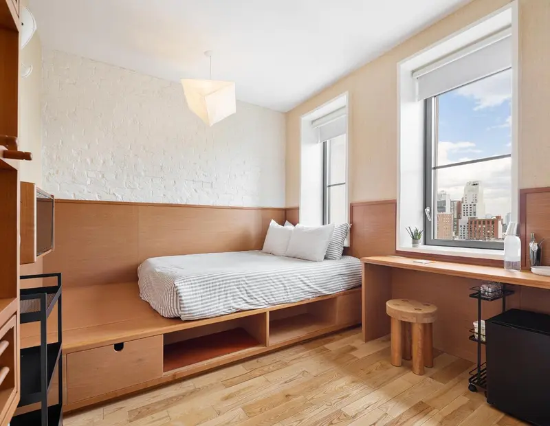 Une chambre lumineuse avec un lit intégré et un bureau près de la fenêtre.