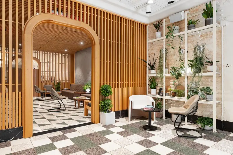 Espace d'attente lumineux avec des sièges et des plantes vertes.