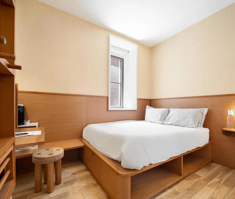 Une chambre lumineuse avec un lit simple et un bureau en bois.