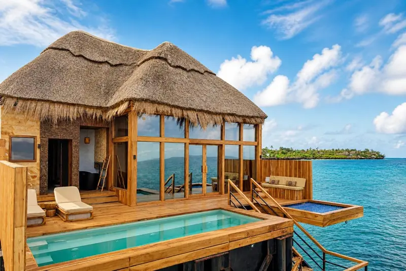 Une villa sur pilotis offre une terrasse avec jacuzzi et vue sur la mer.