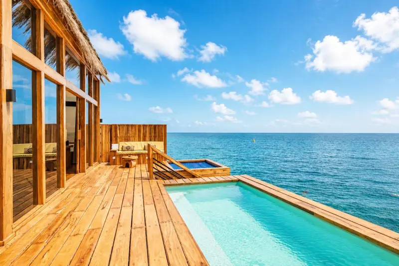 Terrasse en bois avec jacuzzi donnant sur l'océan.