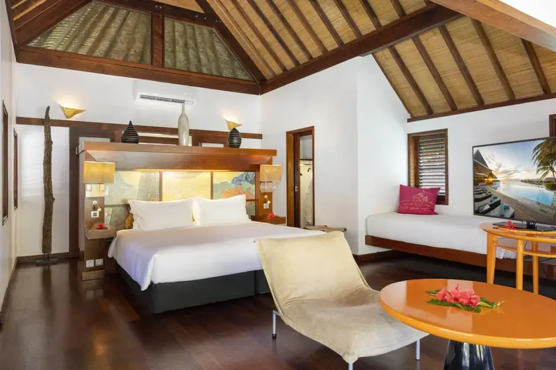 Une chambre lumineuse avec un grand lit et un espace détente.