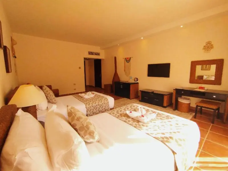 Une chambre lumineuse avec deux lits simples et un coin salon.