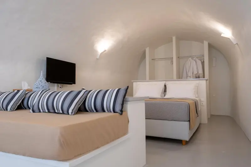 Une chambre à coucher lumineuse avec un lit confortable et un téléviseur mural.