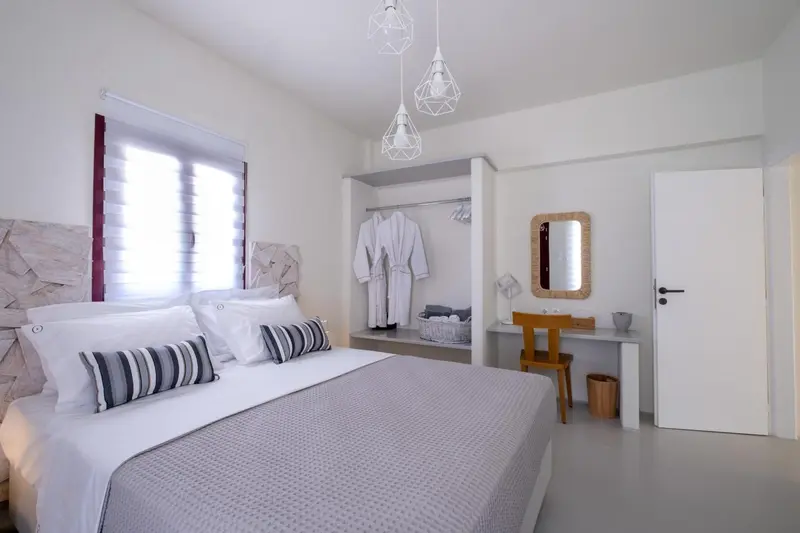 Une chambre lumineuse avec un grand lit et un espace bureau.