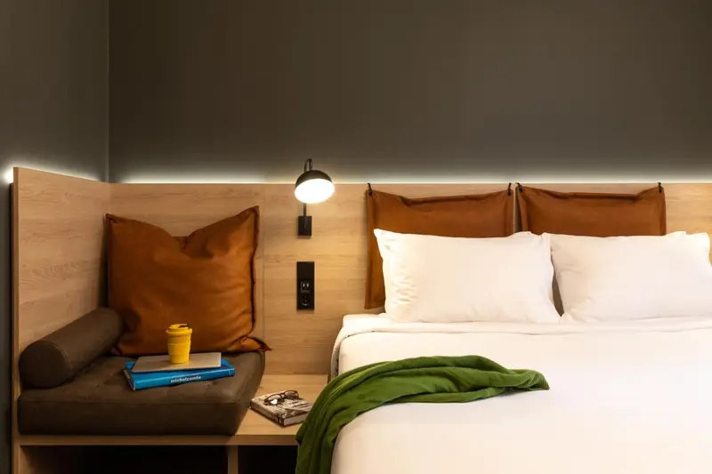 Une chambre avec un grand lit et un coin lecture.