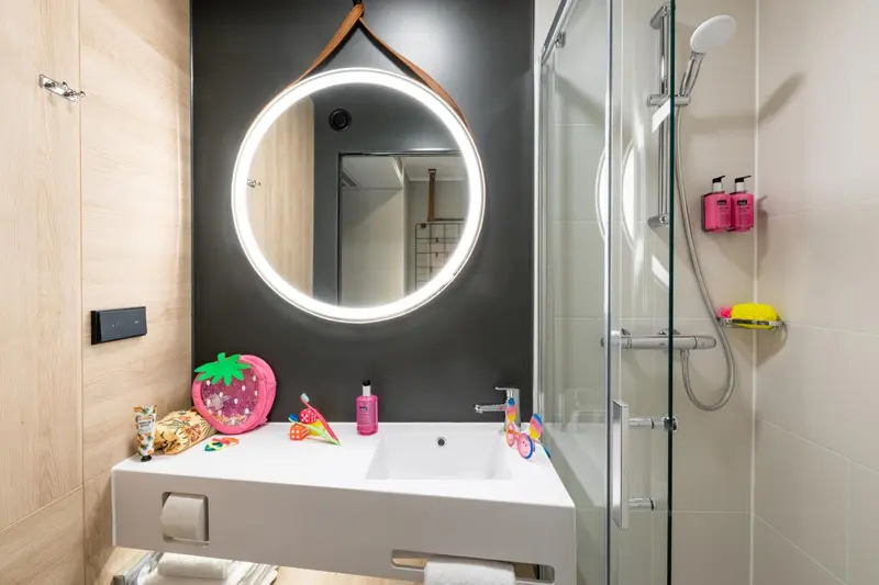 Une salle de bain moderne avec douche à l'italienne et miroir lumineux.