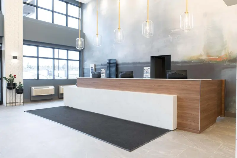 Un comptoir d'accueil moderne dans un hall spacieux et lumineux.