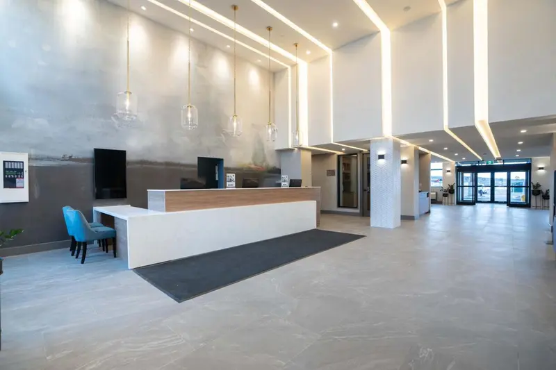 Hall d'accueil moderne avec un comptoir de réception et un éclairage design.