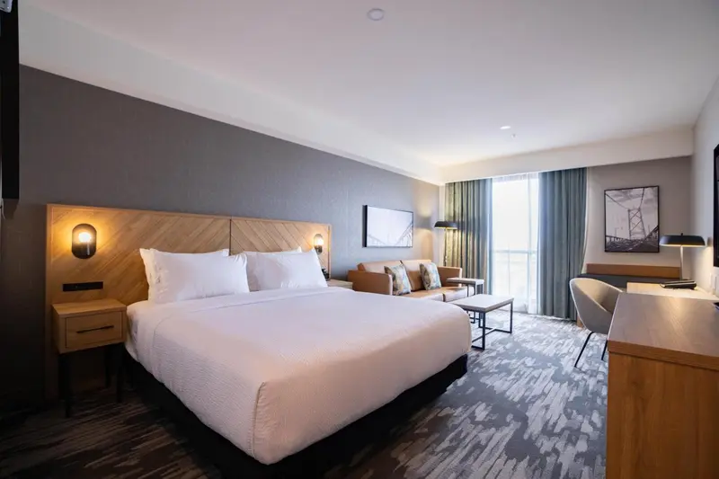 Une chambre lumineuse avec un grand lit et un coin salon.