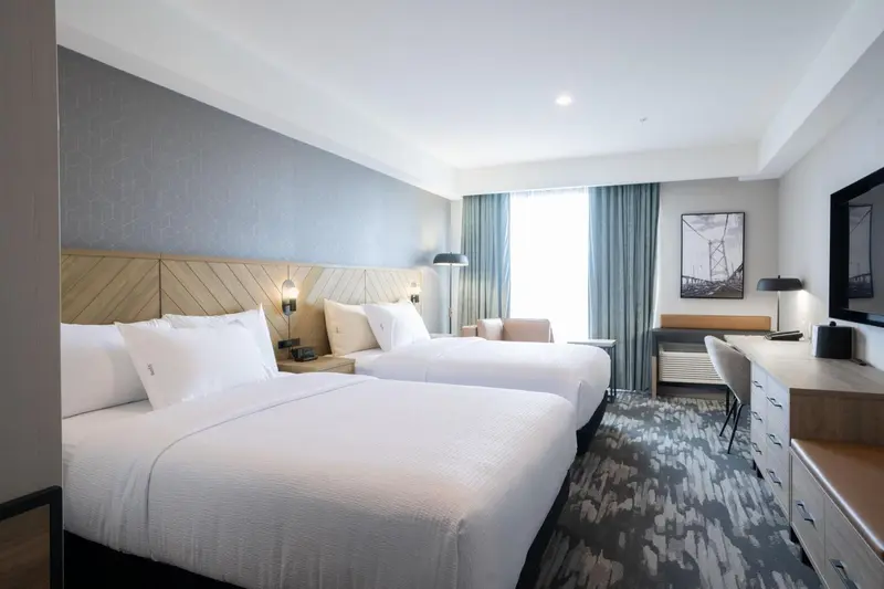 Une chambre d'hôtel avec deux lits et un bureau.