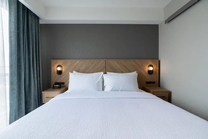 Un lit double avec des oreillers blancs dans une chambre moderne.