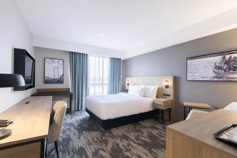 Une chambre d'hôtel lumineuse avec un grand lit et un bureau.