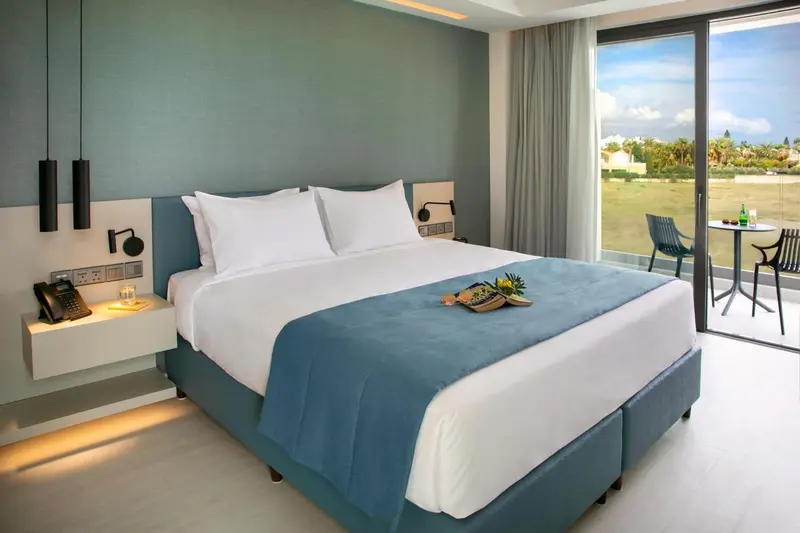 Une chambre lumineuse avec un grand lit et une vue sur un espace extérieur.