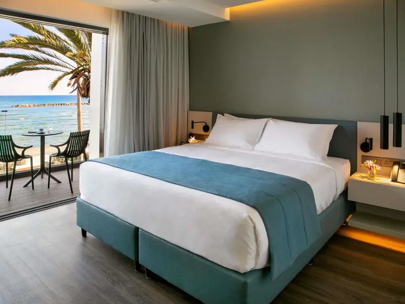 Une chambre lumineuse avec un grand lit donnant sur la mer.