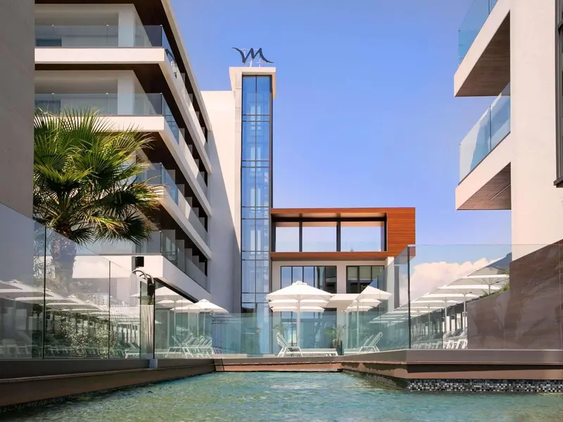 Architecture moderne avec piscine et végétation tropicale.