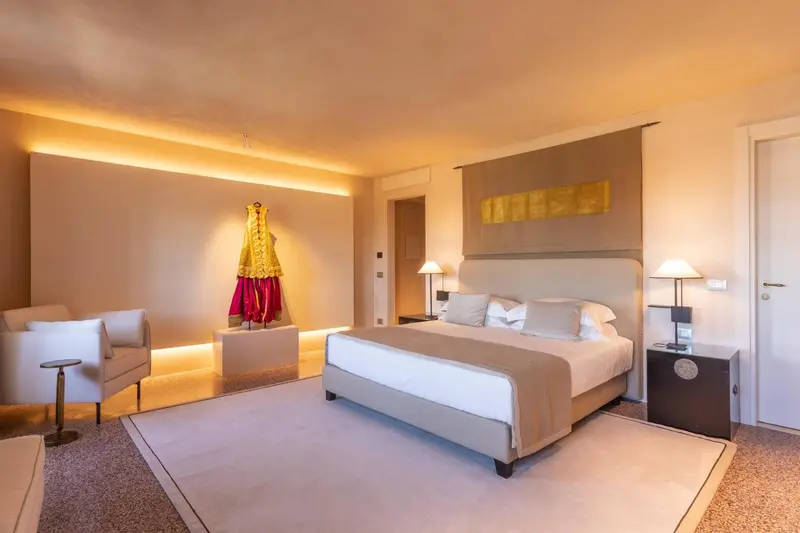 Une chambre lumineuse avec un grand lit et un coin salon.