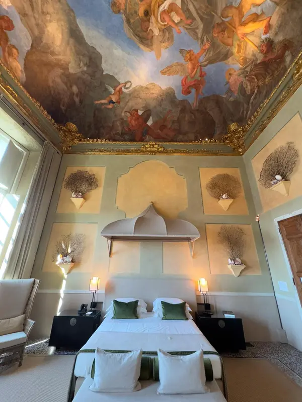 Une chambre à coucher lumineuse avec un lit à baldaquin et une décoration murale ornée.