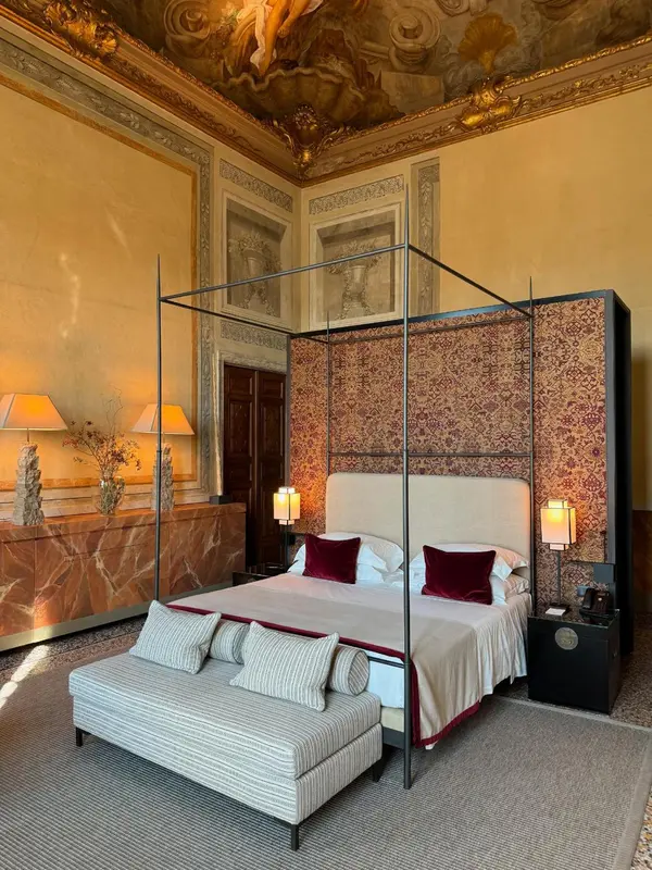 Une chambre à coucher luxueuse avec un lit à baldaquin et des meubles élégants.