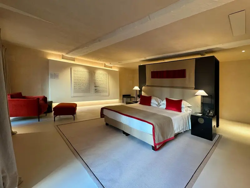 Une chambre lumineuse avec un grand lit et un coin salon.