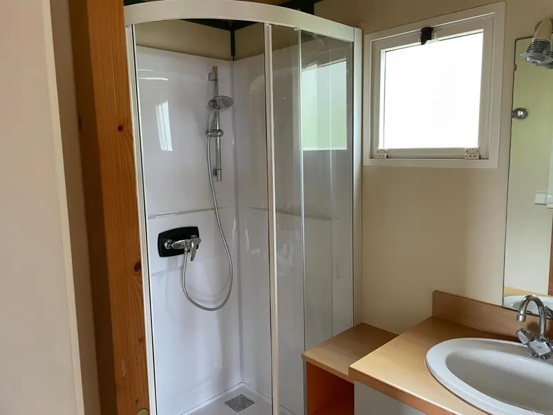 Une douche à l'italienne dans une salle de bain claire.
