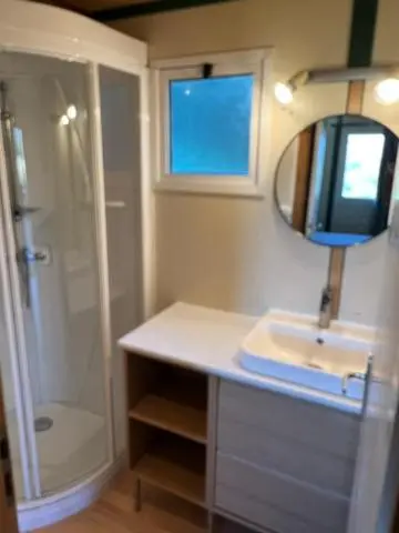 Une salle de bain avec douche et lavabo.