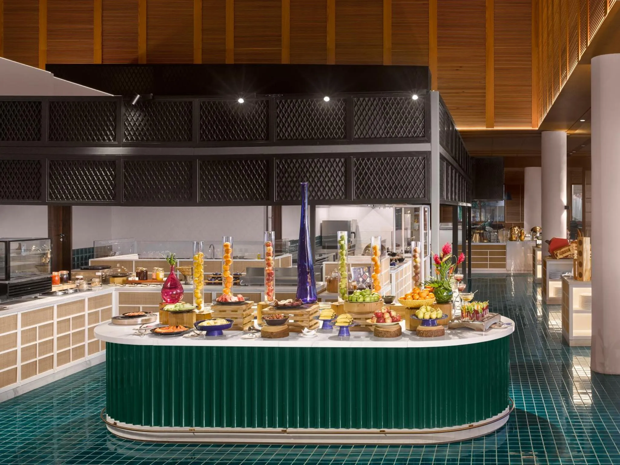 Un buffet de fruits et de salades est présenté sur un comptoir vert.