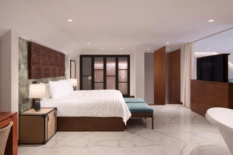 Une chambre lumineuse avec un grand lit et un mobilier en bois.