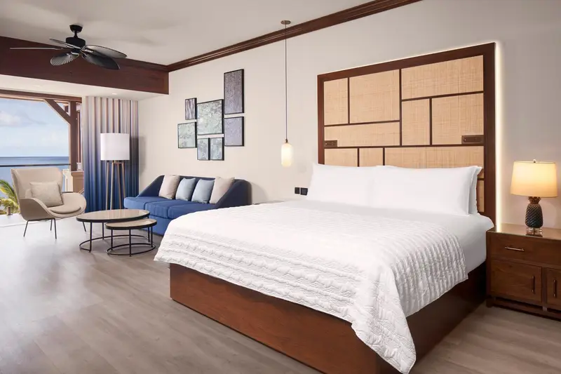 Une chambre lumineuse avec un grand lit et un coin salon.