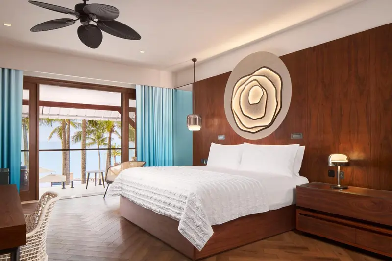 Une chambre lumineuse avec un grand lit et une vue sur la mer.