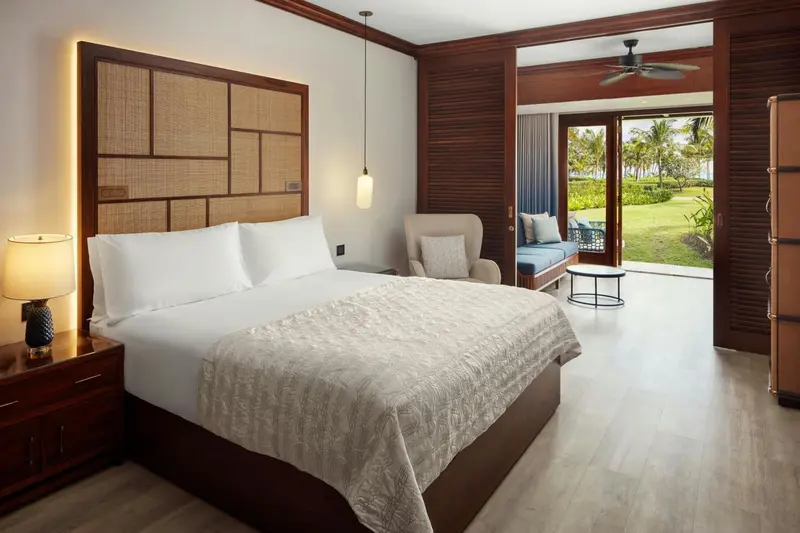 Une chambre lumineuse avec un grand lit et un accès à une terrasse.