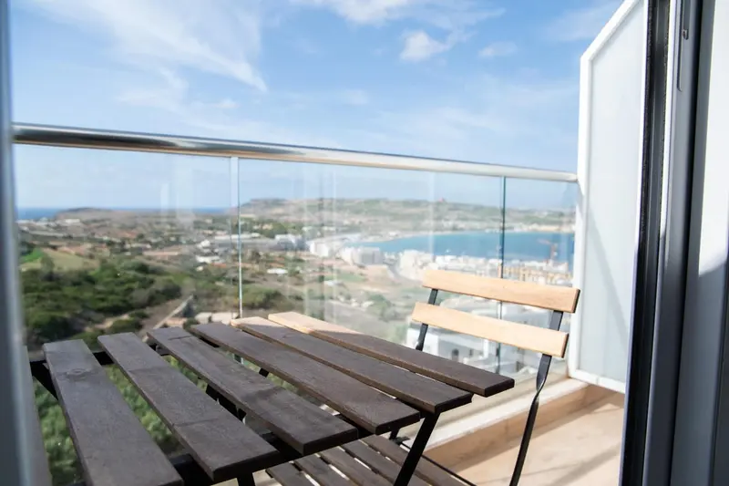 Vue dégagée sur un paysage côtier depuis une terrasse ensoleillée.