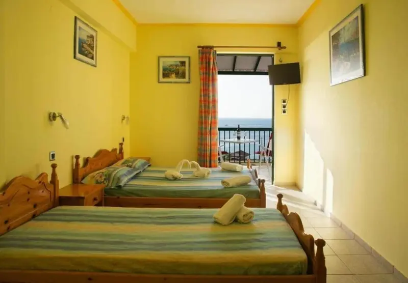 Une chambre lumineuse avec deux lits et un accès à un balcon.