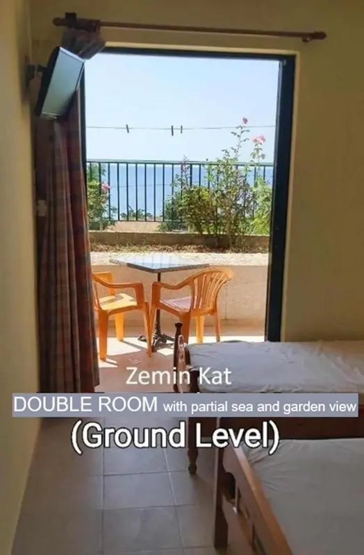 Une chambre avec vue sur une terrasse et la mer.