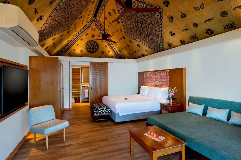 Une chambre lumineuse avec un lit et un espace salon.