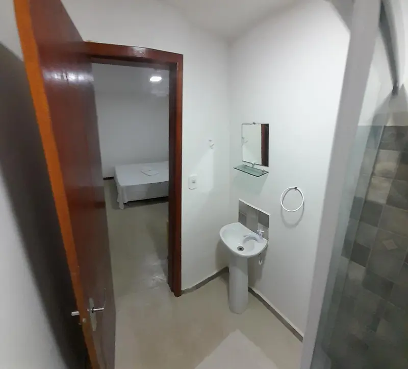 Une salle de bain minimaliste avec douche à l'italienne et lavabo.