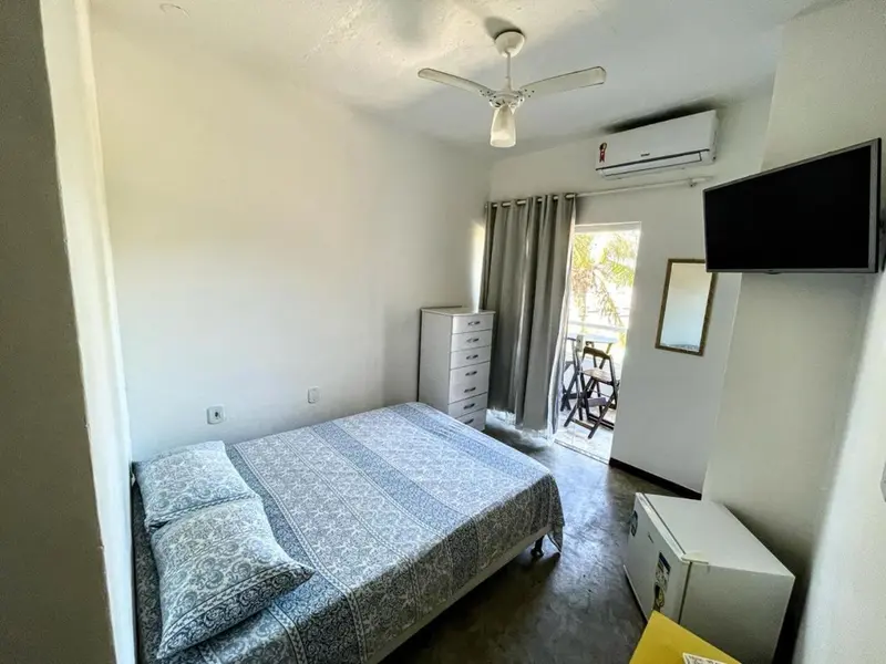 Une chambre lumineuse avec un lit double et un ventilateur au plafond.