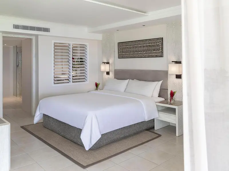 Une chambre lumineuse avec un grand lit et une décoration sobre.