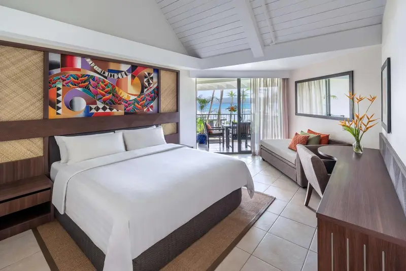 Une chambre lumineuse avec un grand lit et un accès à une terrasse.